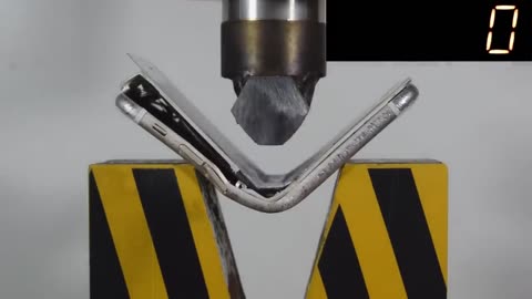 an iPhone is crushed under a hydraulic press: