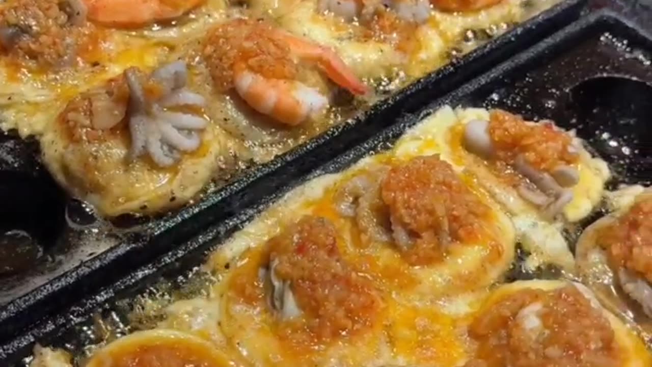 Giant takoyaki with whole seafood stuffed and noodles.