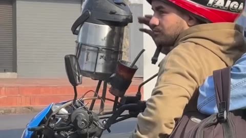 Motorcycling Man Drinks From Beverage Dispenser