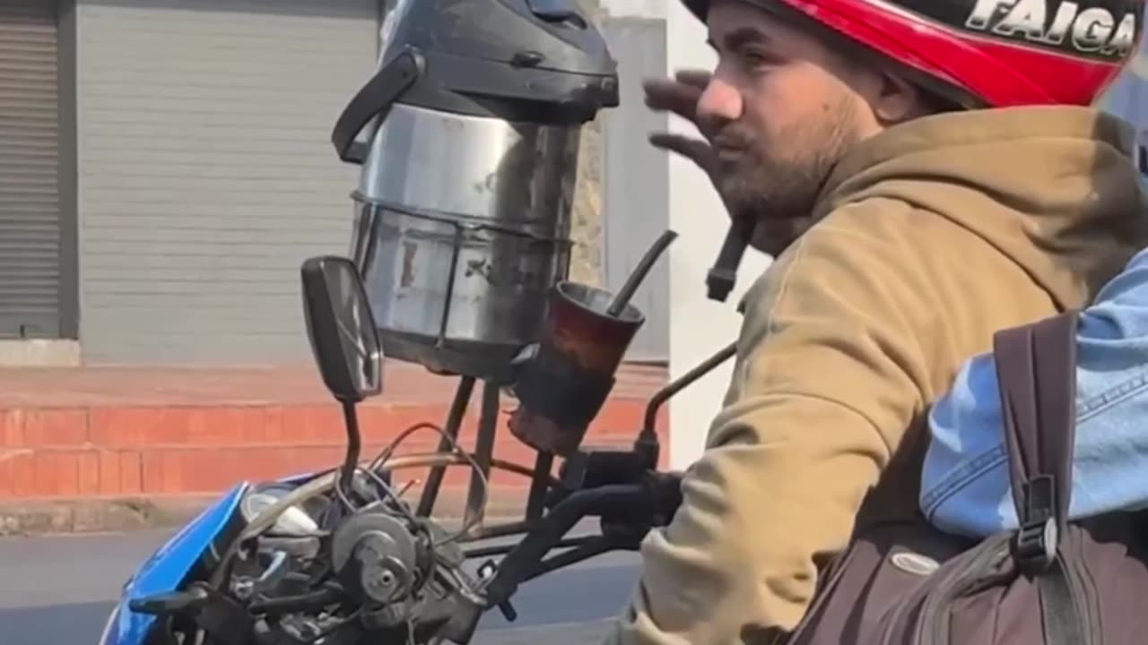 Motorcycling Man Drinks From Beverage Dispenser