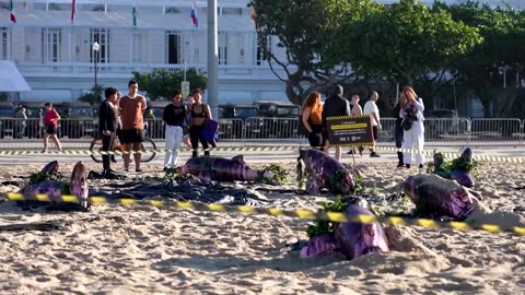 Dolphin models displayed on Copacabana beach in Amazon oil protest