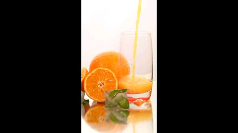 0:04 / 0:15 Serving juice in a glass with some oranges on a white background