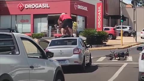 Motociclista se sube al techo de un auto durante una pelea en Brasil