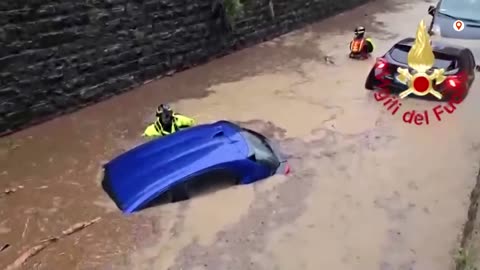 Floodwaters rush through the streets of Como in northern Italy, carrying away debris..........