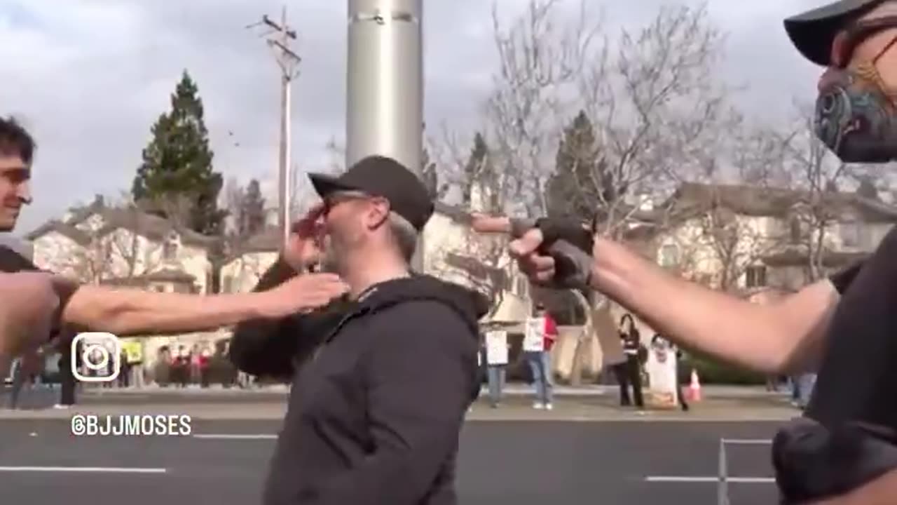 Anti-Elon Protester Knocks Off a Dude's Hat Not Realizing the Dude Knows Jiu Jitsu