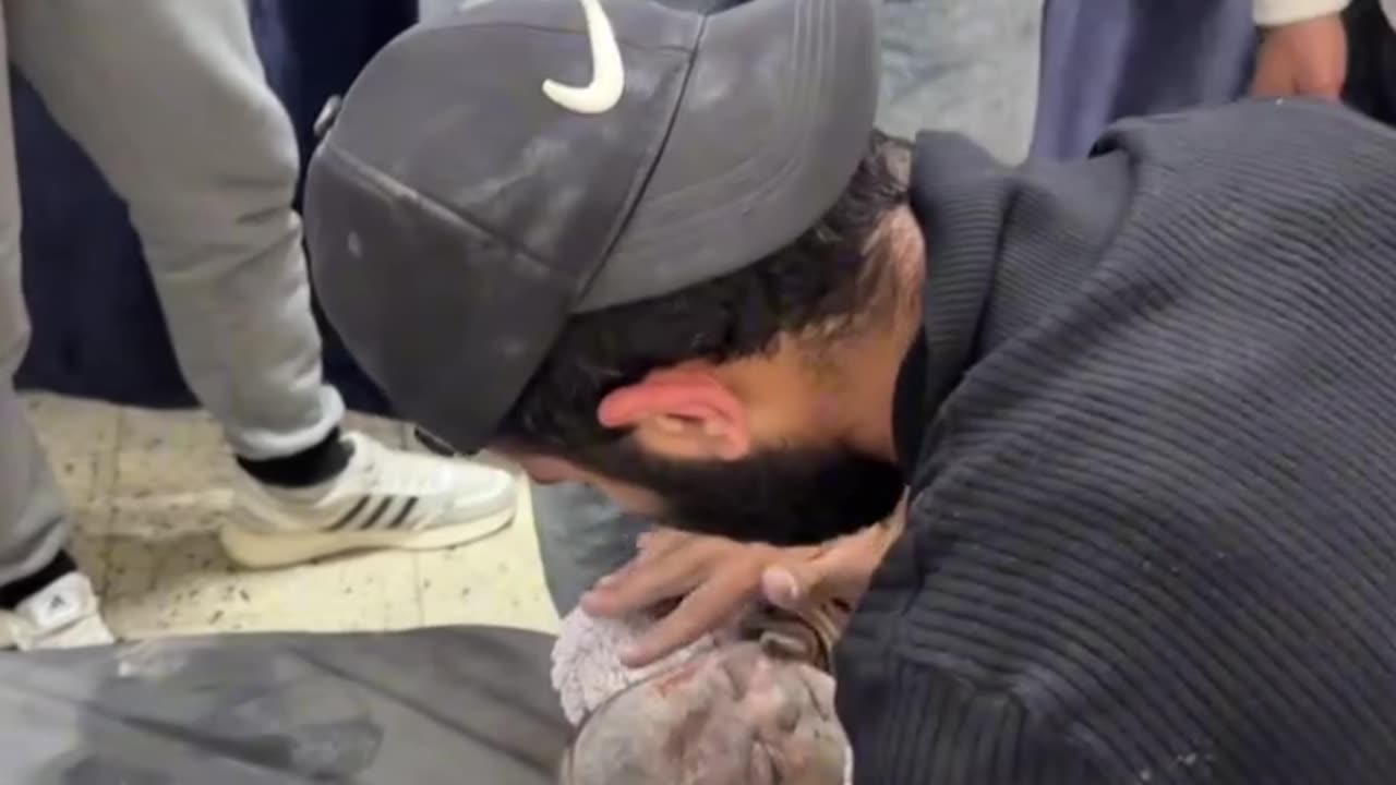 A father bids farewell to his infant daughter who was just killed