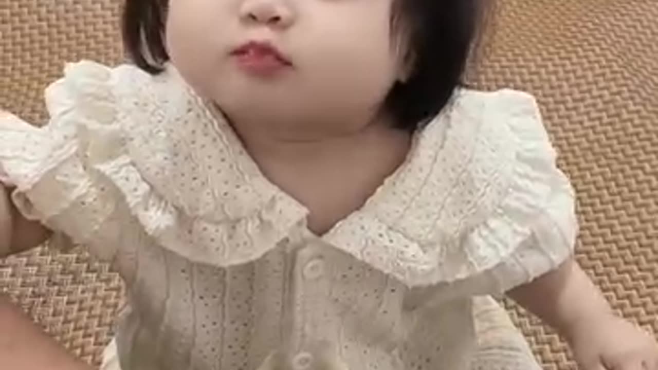 A cute baby is eating banana and smiling