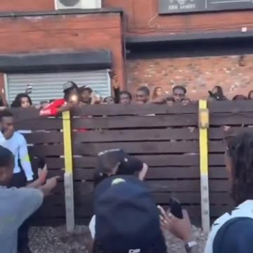 British policeman surrounded by a crowd of blk people