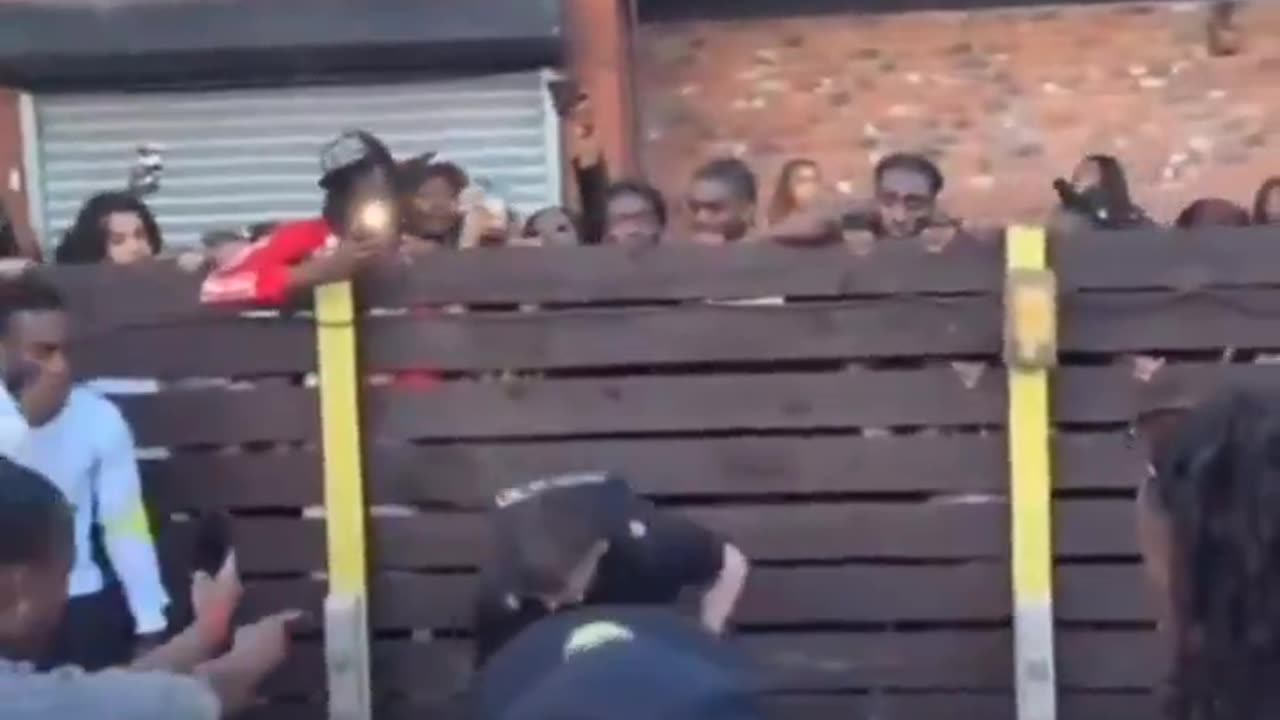 British policeman surrounded by a crowd of blk people