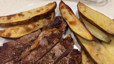 Frying a steak in a closed-top pan to reduce house smoke