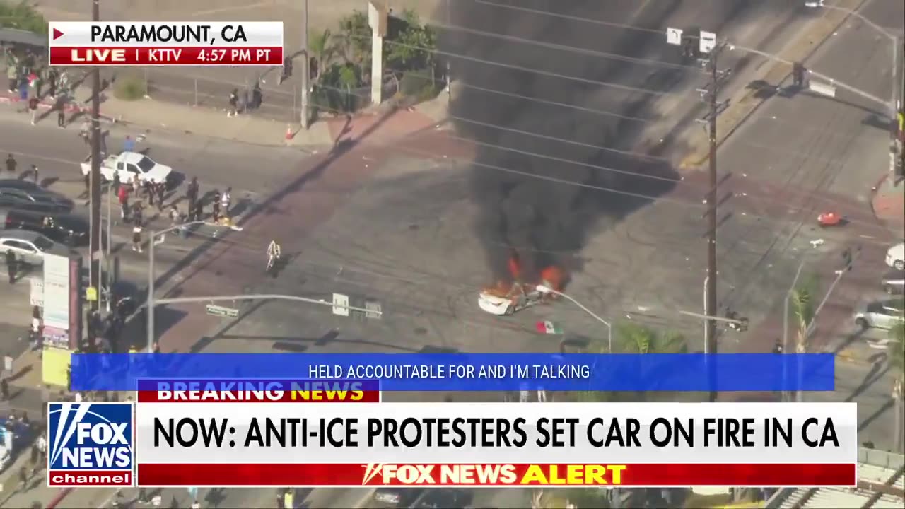 Man with a Mexican flag circles a burning car during anti-ICE unrest in Los Angeles