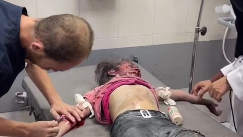 A wounded young girl screams in pain, crying for her missing father