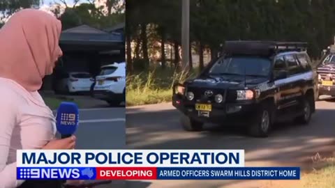 In the northwest of Sydney, police swarm a house.