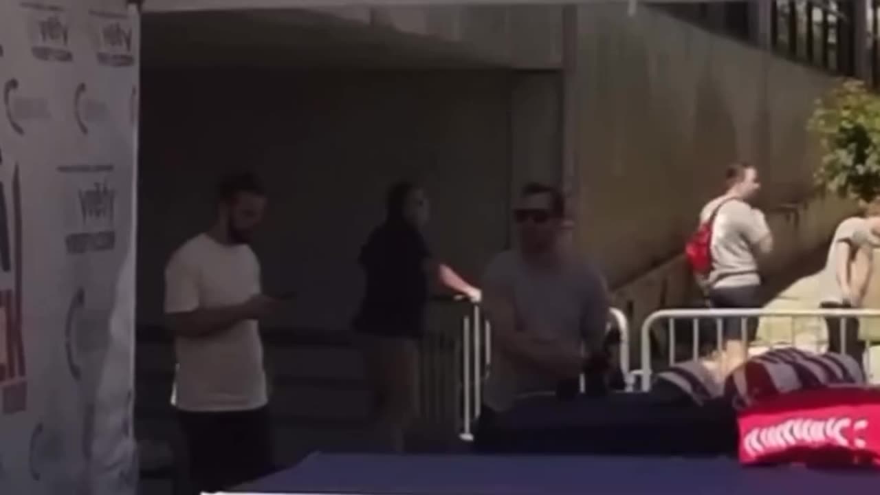 A man in a gray shirt stole a camera from behind Charlie Kirk