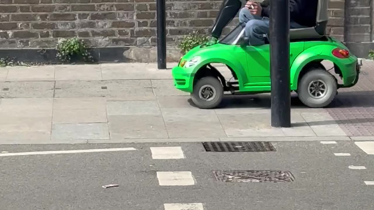 Man Drives Toy Car On London Sidewalk