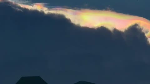 Iridescent Rainbow Peaks Over Clouds