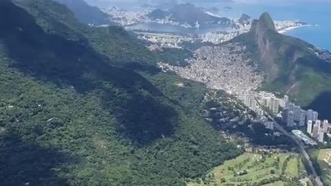 A tourist sitting on top of the Pedra da Gávea Mountain, Brazil