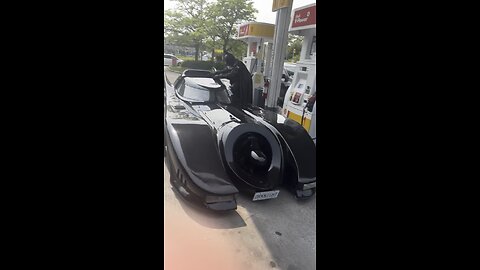 Batman gassing up the Batmobile