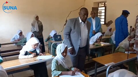 The Governor of Gezira rings the bell to mark the start of the primary school exams.