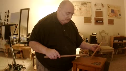 Showing drumming on a wooden table.