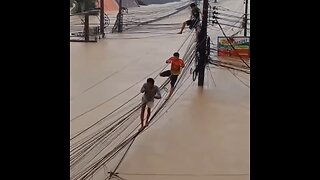 Tailandeses se suben al tendido eléctrico para escapar de las inundaciones