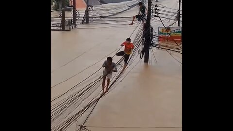 Tailandeses se suben al tendido eléctrico para escapar de las inundaciones