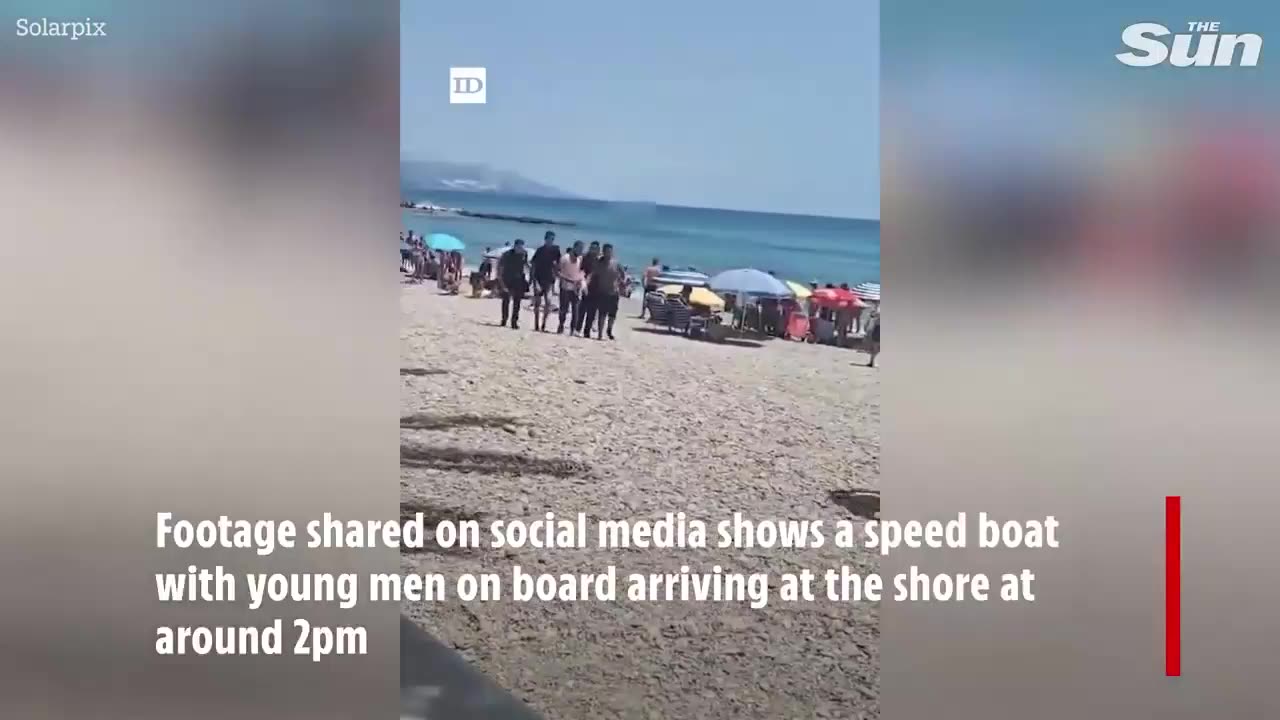 Migrants who unexpectedly arrived on a Spanish beach by boat being seized by angry locals and held until authorities arrived!