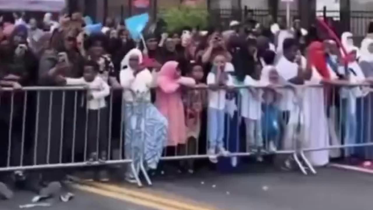 Minneapolis Mayor Jacob Frey waves the Somali flag and leads a chant in a foreign language on stage