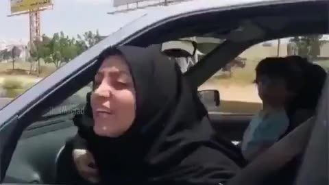 In Iran, a woman wearing a black chador is attacking a woman in another car for ..