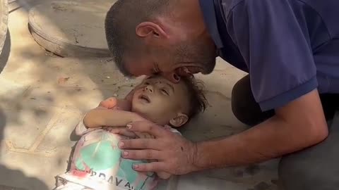 A Palestinian father weeping over the lifeless body of his young child