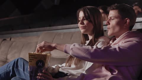 Beautiful couple eating popcorn and enjoying