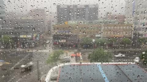 منظر مدينة خلف زجاج مبلل بالمطر