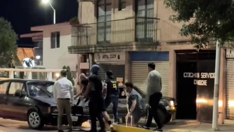Group of Men Lift a Car Back Over Median