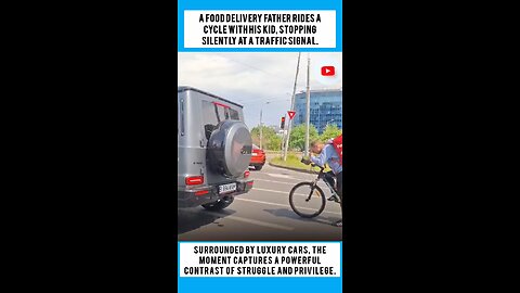 A food delivery father rides a cycle with his kid, stopping silently at a traffic signal.