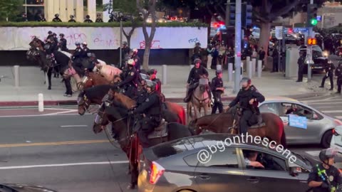 Los Angles Police ride horses to disperse rioters from downtown