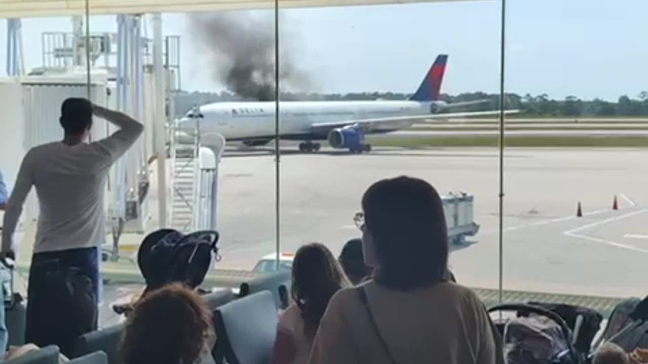 Crowd Watches Delta Plane Catch Fire From Airport Terminal