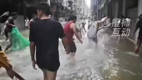 #Macau streets — now residents are wading in and catching fish like it’s a giant pond. #typhoon