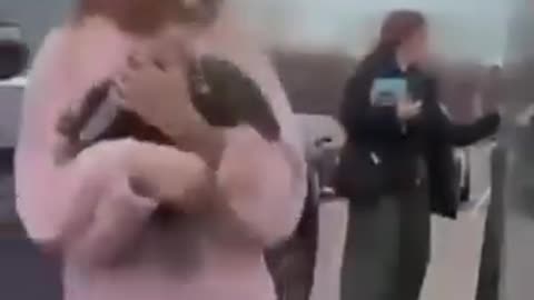 Mother vandalizing a Tesla as her daughter flips off the camera. So, not just damaging property