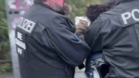 Young, small-framed protester being suddenly seized from behind