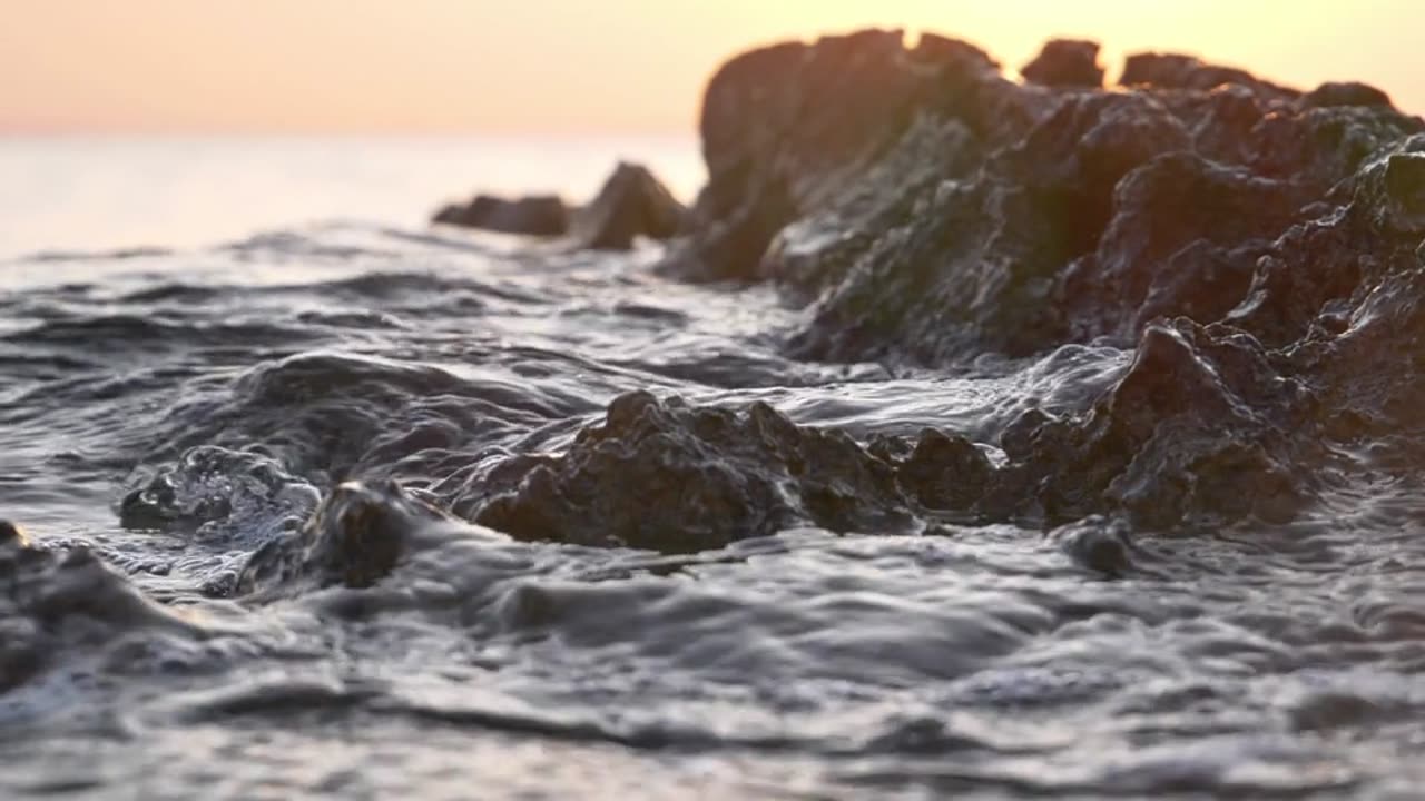 Sea water movement around beach rock, slow motion
