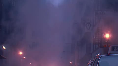 street level wide shot steam rises from manholes