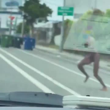Naked migrant jumped on top of a moving car.
