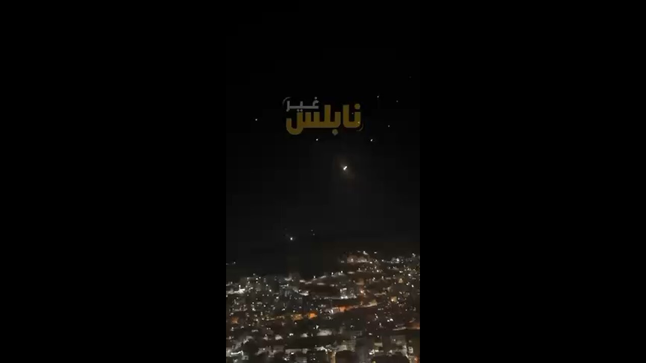 Palestinians cheer as they watch itanian missiles.