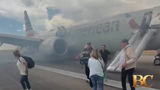 Passengers exit plane via emergency slide after aborted takeoff