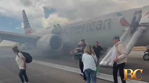 Passengers exit plane via emergency slide after aborted takeoff