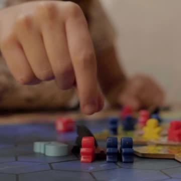 Girl moving small figures from a board game