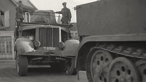 Heavy gun towed by five linked half tracks through French streets to form part of the Atlantic Wall