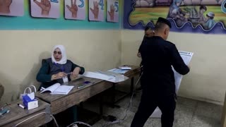 Iraqi security forces cast votes before polls open to the public