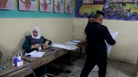 Iraqi security forces cast votes before polls open to the public