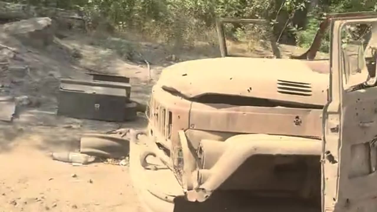 Russian Soldiers Navigate the Dozens of Destroyed Vehicles Lining the Roadway